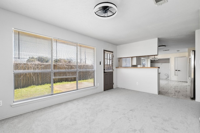 unfurnished living room featuring light colored carpet