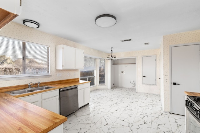 kitchen with sink, butcher block countertops, hanging light fixtures, black dishwasher, and white cabinets