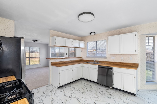 kitchen featuring white cabinets, kitchen peninsula, sink, and black appliances