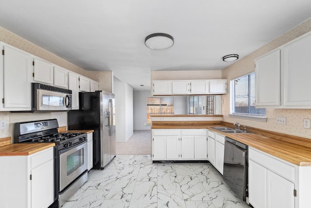 kitchen featuring appliances with stainless steel finishes, sink, and white cabinets