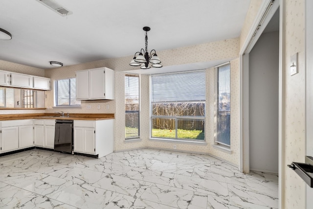 kitchen featuring decorative light fixtures, white cabinetry, black dishwasher, wooden counters, and an inviting chandelier