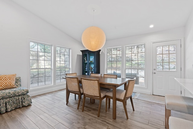 dining area featuring lofted ceiling and light hardwood / wood-style floors