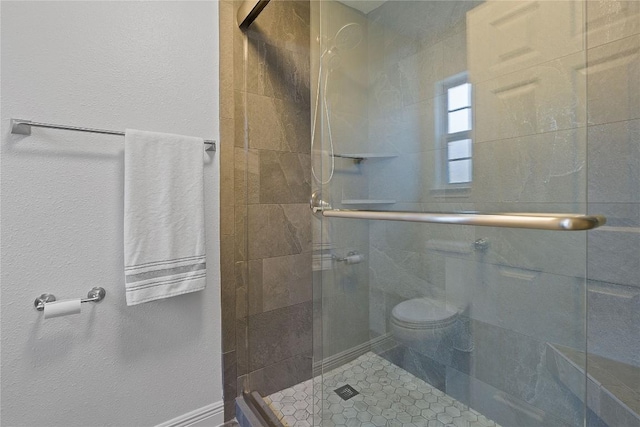 bathroom with toilet and a shower with shower door