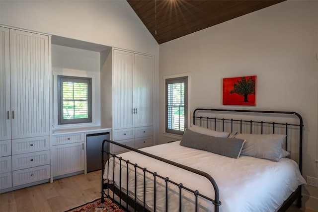 bedroom featuring high vaulted ceiling, wood ceiling, light hardwood / wood-style flooring, and fridge