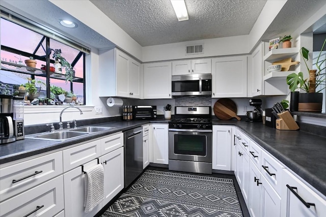 kitchen with stainless steel appliances, sink, and white cabinets