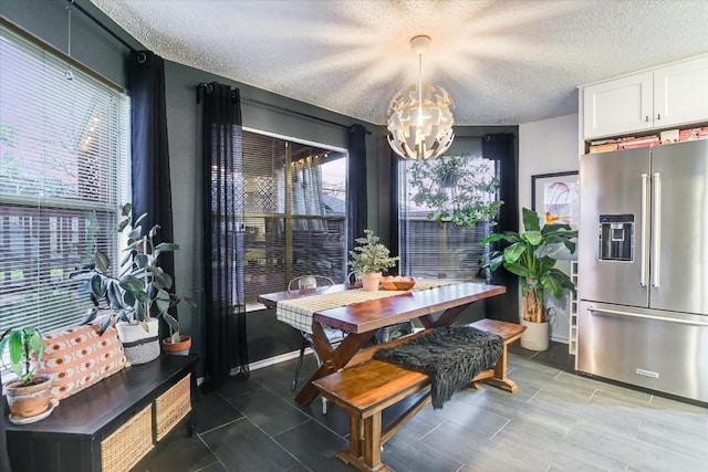 dining space featuring a notable chandelier and a textured ceiling