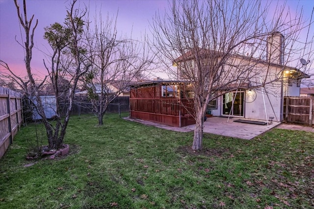 yard at dusk featuring a patio