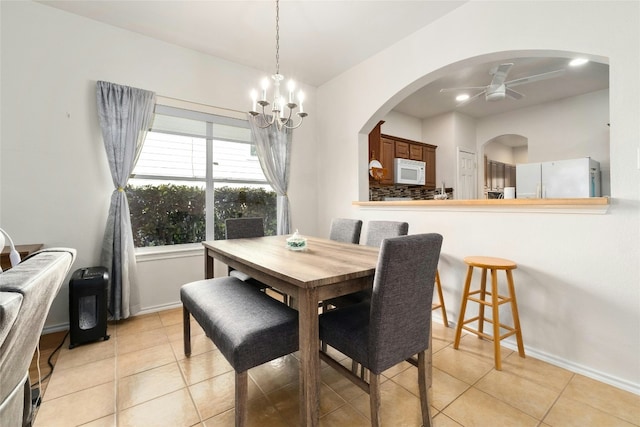 dining room with ceiling fan with notable chandelier and light tile patterned floors