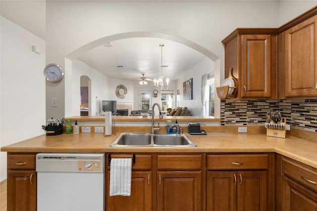 kitchen with sink, an inviting chandelier, backsplash, and white dishwasher