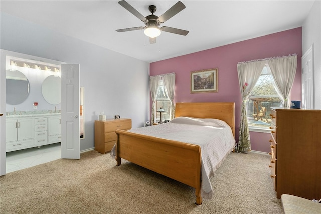 bedroom with multiple windows, sink, light colored carpet, and ensuite bath