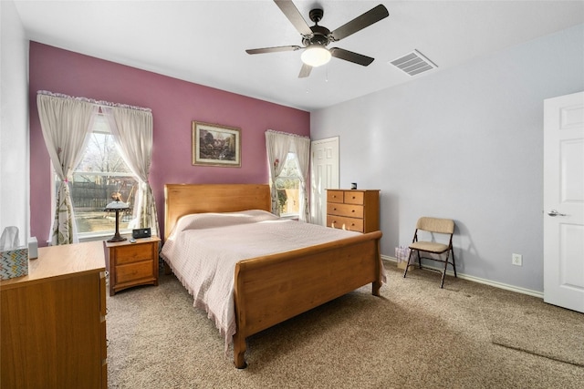 carpeted bedroom featuring multiple windows and ceiling fan