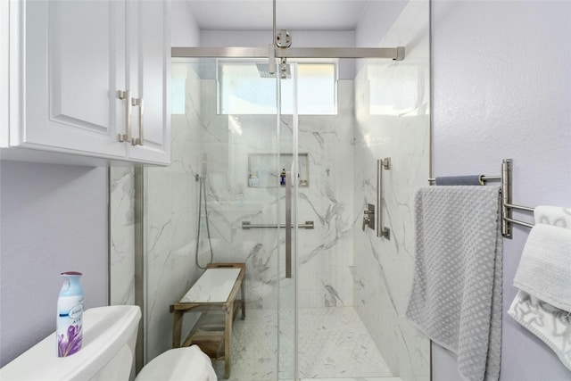 bathroom featuring toilet and a shower with shower door