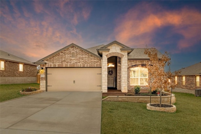 view of front of property featuring a garage and a lawn