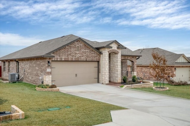 french provincial home featuring a garage, a front lawn, and central air condition unit