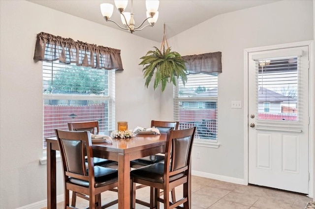 dining space featuring light tile patterned flooring, lofted ceiling, and a chandelier