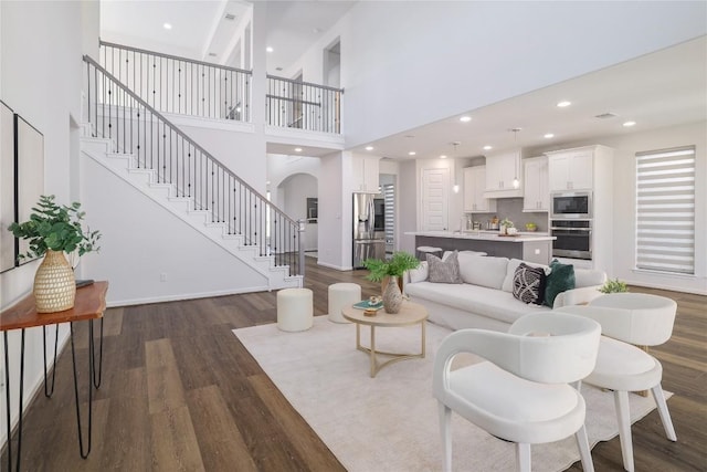 living room featuring dark hardwood / wood-style flooring and a high ceiling