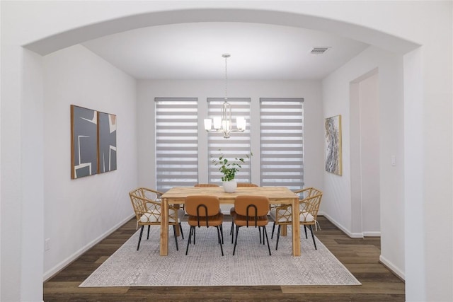 dining room featuring dark hardwood / wood-style flooring and a notable chandelier