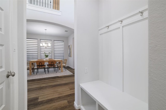 mudroom with a notable chandelier and dark wood-type flooring