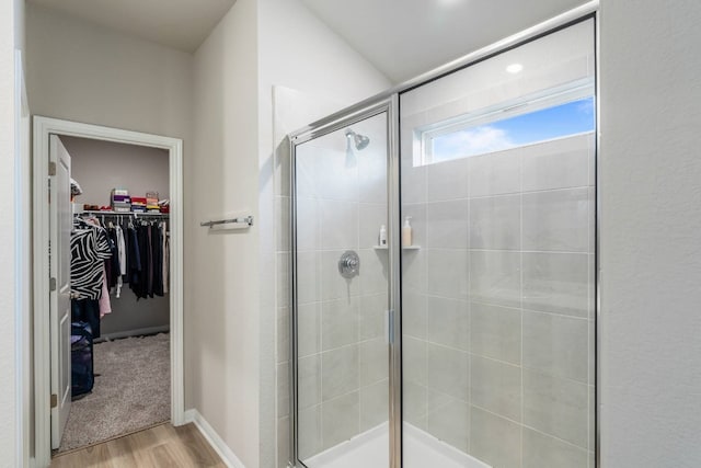 bathroom with wood-type flooring and an enclosed shower