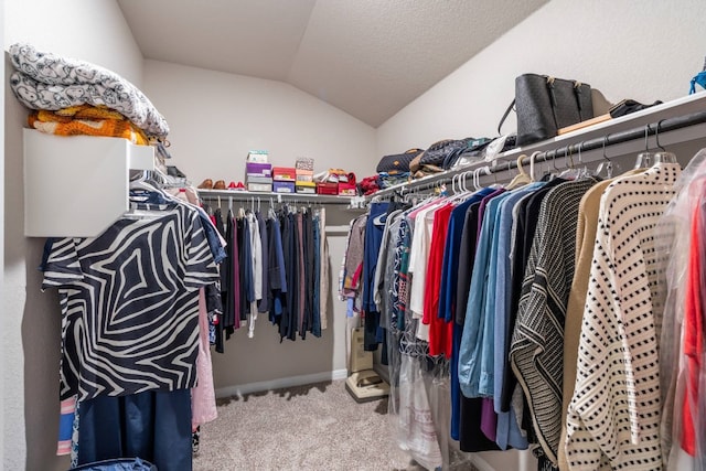 walk in closet with lofted ceiling and carpet