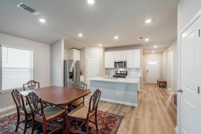 dining room with sink and light wood-type flooring