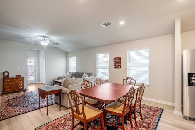 dining space with vaulted ceiling, ceiling fan, and light wood-type flooring