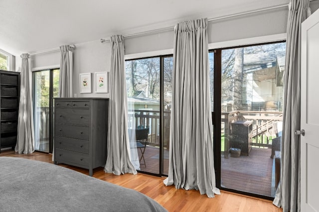 bedroom with access to outside and light wood-type flooring