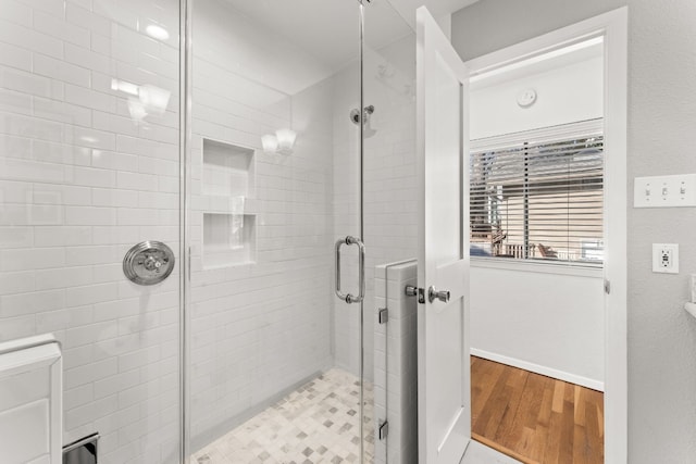 bathroom featuring hardwood / wood-style floors and a shower with shower door