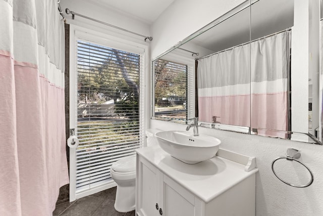 bathroom with tile patterned flooring, vanity, and toilet