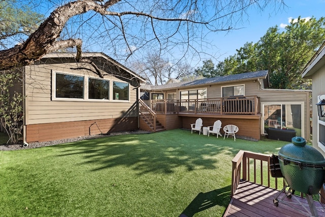 rear view of property with a yard and a deck