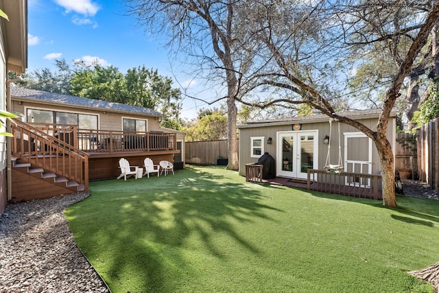 view of yard featuring a wooden deck, an outdoor structure, and french doors