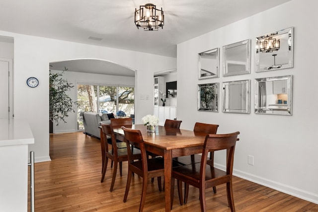 dining space featuring an inviting chandelier and hardwood / wood-style floors