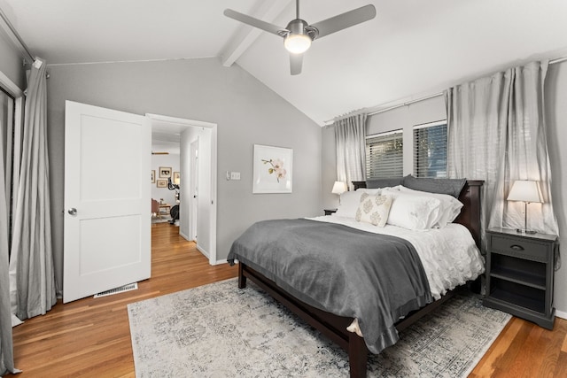 bedroom with lofted ceiling with beams, hardwood / wood-style floors, and ceiling fan