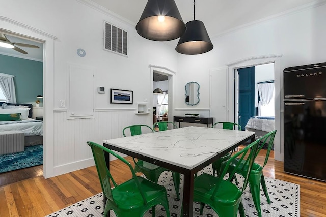 dining room featuring crown molding, ceiling fan, and hardwood / wood-style flooring