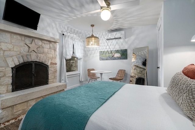 bedroom with ceiling fan, a fireplace, and an AC wall unit