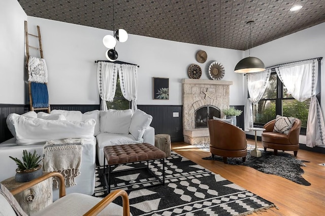 living room with wood-type flooring and a stone fireplace