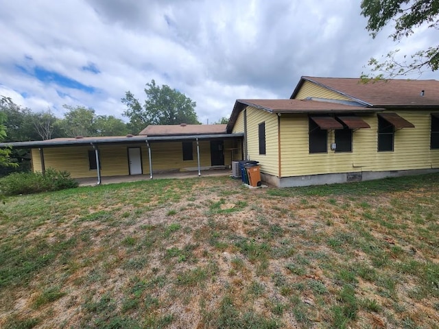 back of property featuring a yard, cooling unit, and a patio area