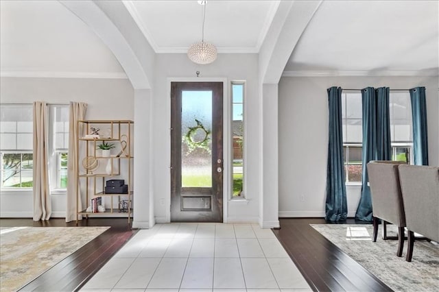 foyer entrance featuring ornamental molding, plenty of natural light, and light wood-type flooring