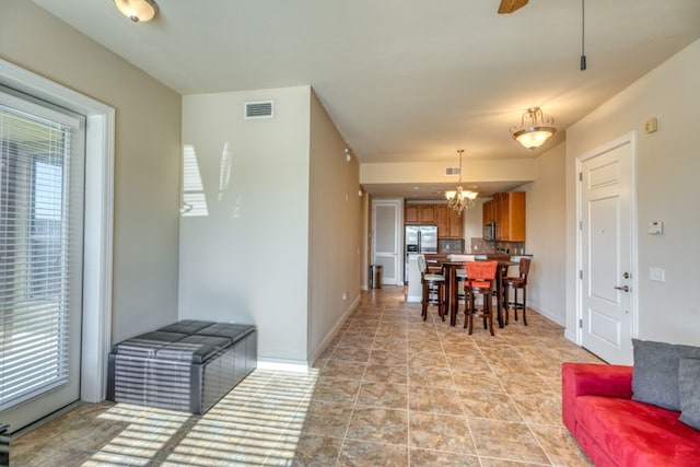 living room featuring a healthy amount of sunlight and ceiling fan with notable chandelier