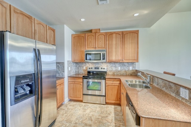 kitchen with sink, stainless steel appliances, light stone counters, decorative backsplash, and light brown cabinets