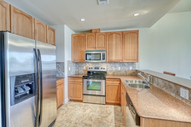 101 W Bank Unit 27, Horseshoe Bay, TX 78657 - kitchen featuring stainless steel appliances, a sink, light brown cabinetry, a peninsula, and decorative backsplash