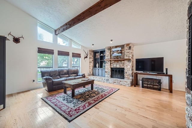 living room featuring beam ceiling, high vaulted ceiling, a textured ceiling, a fireplace, and hardwood / wood-style floors