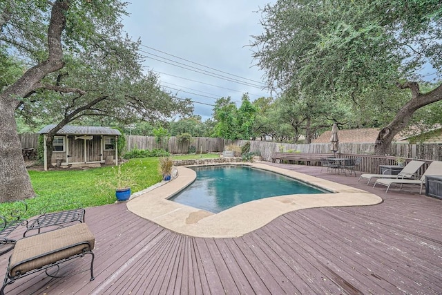 view of pool featuring a yard, an outbuilding, and a deck