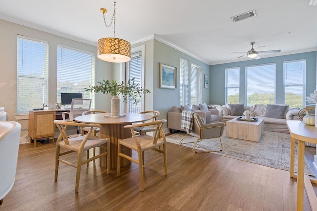 dining area featuring crown molding, light hardwood / wood-style floors, and ceiling fan