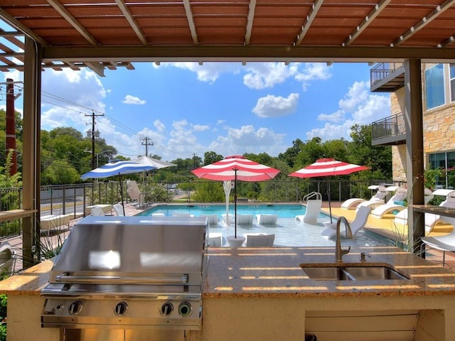 view of patio with area for grilling, a fenced in pool, grilling area, and sink