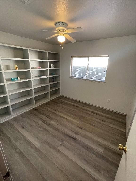 spare room with dark hardwood / wood-style flooring, a textured ceiling, and ceiling fan