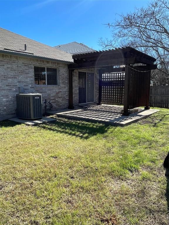 rear view of property featuring a pergola, cooling unit, and a lawn