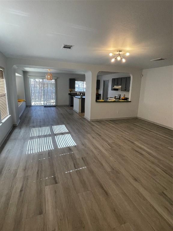 unfurnished living room featuring dark hardwood / wood-style floors and a chandelier