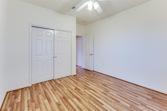 unfurnished bedroom featuring ceiling fan, light hardwood / wood-style floors, and a closet