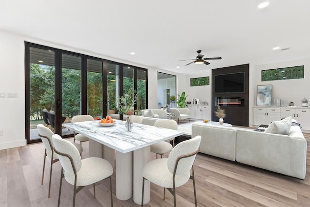 dining area with plenty of natural light, ceiling fan, and light wood-type flooring